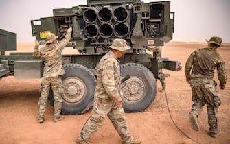 US soldier walk past an M142 High Mobility Artillery Rocket System (HIMARS) launcher vehicle, during the "African Lion" military exercise in the Grier Labouihi region in southeastern Morocco on June 9, 2021. (Photo by FADEL SENNA / AFP) (Photo by FADEL SENNA/AFP via Getty Images)