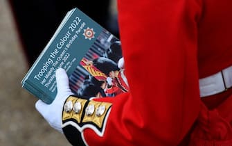 A member of the Coldstream Guards holds souvenir programs ahead of the start of the Queen's Birthday Parade, the Trooping the Colour, as part of Queen Elizabeth II's platinum jubilee celebrations, in London on June 2, 2022. - Huge crowds converged on central London in bright sunshine on Thursday for the start of four days of public events to mark Queen Elizabeth II's historic Platinum Jubilee, in what could be the last major public event of her long reign. (Photo by TOBY MELVILLE / POOL / AFP) (Photo by TOBY MELVILLE/POOL/AFP via Getty Images)