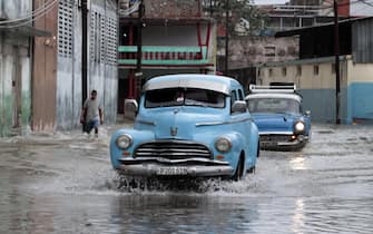 epa09994491 A classic car drives down a flooded street in Havana, Cuba, 03 June 2022. The remnant of Hurricane Agatha, which left nine dead and four missing in Mexico, is causing intense and persistent rains this Friday in western Cuba. The island's authorities have already warned about this meteorological phenomenon, which according to the US National Hurricane Center (NHC) continues to strengthen and may become the first tropical storm in the Atlantic this season.  EPA / Ernesto Mastrascusa