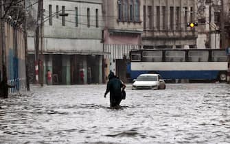 epa09994485 Several people walk along a flooded street in Havana, Cuba, 03 June 2022. The remnant of Hurricane Agatha, which left nine dead and four missing in Mexico, is causing intense and persistent rains this Friday in western Cuba. The island's authorities have already warned about this meteorological phenomenon, which according to the US National Hurricane Center (NHC) continues to strengthen and may become the first tropical storm in the Atlantic this season.  EPA/Ernesto Mastrascusa