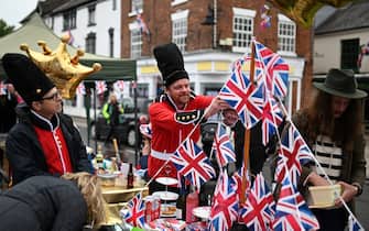 A reveller dressed-up like a Queen Foot Guard takes care of the table decorations during a street party in Ashby-de-la-Zouch in central England on June 5, 2022 as part of Queen Elizabeth II's platinum jubilee celebrations. - Millions of people are expected to attend "Big Jubilee Lunch" picnics, as a long weekend of festivities to honour Queen Elizabeth II's historic Platinum Jubilee concludes. (Photo by Oli SCARFF / AFP) (Photo by OLI SCARFF/AFP via Getty Images)