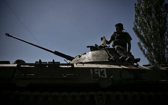 A member of the Ukrainian troops stands on an armoured vehicle moving towards the front line in the city of Lysychansk in the eastern Ukraine region of Donbas on June 9, 2022, as Russian forces have for weeks been concentrating their firepower on Severodonetsk and its sister city of Lysychansk across the river. - A defiant Lugansk governor declares that Ukrainian forces could reclaim Severodonetsk "in two to three days" if they receive long-range artillery promised by the US and Britain. (Photo by ARIS MESSINIS / AFP) (Photo by ARIS MESSINIS/AFP via Getty Images)