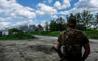 LYSYCHANSK, UKRAINE - 2022/05/27: A soldier looks at the smoke coming from the oil refinery of Lysychansk Lysychansk is a city on the high right bank of the Donets River in the Luhansk region. The city is part of a metropolitan area including Severodonetsk and Rubizhne; the three towns constitute one of Ukraine's largest chemical complexes. Lysychansk is now the frontline since the Russians destroyed the bridge connecting Severodonetsk to Lysychansk. Russian troops are attacking the city and moving towards it. The Russian army occupies the main road that connects Lysychansk to Kramatorsk. (Photo by Rick Mave/SOPA Images/LightRocket via Getty Images)