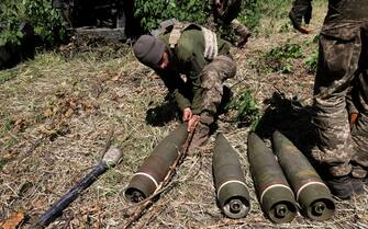 epa09999060 Ukrainian servicemen prepapre ammunition for a M777 howitzer at a frontline in the Donetsk area, Ukraine, 06 June 2022 amid heavy battles in the region. On 24 February, Russian troops had entered Ukraine causing fighting and destruction in the country and a humanitarian crisis.  EPA/STR