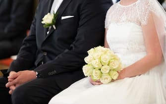 PRODUCTION - 26 June 2021, Baden-Wuerttemberg, Schiltach: A bride and groom sit in church during their wedding ceremony. Photo: Silas Stein/dpa (Photo by Silas Stein/picture alliance via Getty Images)