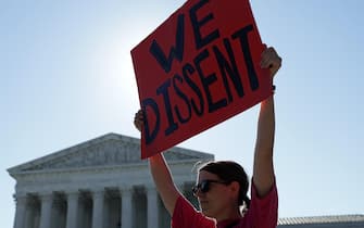 WASHINGTON, DC - JUNE 25:  An anti-abortion activist holds up a sign that read "We Dissent" in front of the U.S. Supreme Court on June 25, 2022 in Washington, DC. The Supreme Court's decision in Dobbs v Jackson Women's Health overturned the landmark 50-year-old Roe v Wade case and erased a federal right to an abortion. (Photo by Alex Wong/Getty Images)