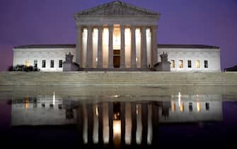 The US Supreme Court is reflected in a puddle of water in Washington, DC, on April 5, 2022. (Photo by Stefani Reynolds / AFP) (Photo by STEFANI REYNOLDS/AFP via Getty Images)