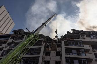 epa10034585 Rescuers work atop a damaged residential building following Russian airstrikes in the Shevchenkivskiy district of Kyiv (Kiev), Ukraine, 26 June 2022. Multiple airstrikes hit the center of Kyiv in the morning. Russian troops on 24 February entered Ukrainian territory, starting the conflict that has provoked destruction and a humanitarian crisis.  EPA/ROMAN PILIPEY