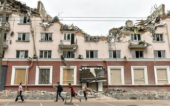 People walk near the remains of hotel Ukraine, destroyed in a Russian missile strike in Chernihiv city, Ukraine, 23 June 2022. On 24 February Russian troops entered Ukrainian territory starting a conflict that has provoked destruction and a humanitarian crisis.  ANSA/OLEG PETRASYUK
