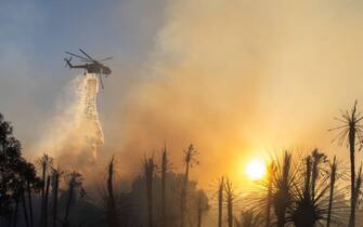 JURUPA VALLEY, CA - JUNE 17: A water-dropping helicopter battles a brush fire that broke out Friday afternoon on June 17, 2022 in Jurupa Valley, California. (Photo by Qian Weizhong/VCG via Getty Images)