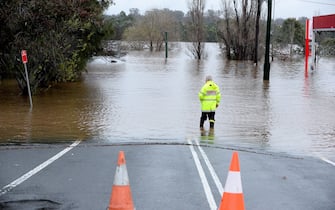 A rescue worker examines a flooded area due to torrential rain in the Camden suburb of Sydney on July 3, 2022. - Thousands of Australians were ordered to evacuate their homes in Sydney on July 3 as torrential rain battered the country's largest city and floodwaters inundated its outskirts.  (Photo by Muhammad FAROOQ / AFP) (Photo by MUHAMMAD FAROOQ / AFP via Getty Images)