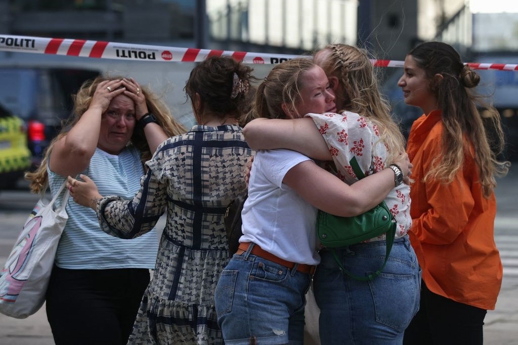 People embrace as police evacuate of the Fields shopping center in Copenhagen, Denmark, on July 3, 2022 after Danish media reported a shooting. - Gunfire in a Copenhagen mall left "several dead," and several wounded Danish police said.
 - Denmark OUT (Photo by Olafur Steinar Gestsson / Ritzau Scanpix / AFP) / Denmark OUT (Photo by OLAFUR STEINAR GESTSSON/Ritzau Scanpix/AFP via Getty Images)