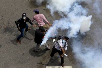1241806750 An anti-government protester throws back a gas canister during a protest demanding president and prime minister to step down near president's residence at Colombo, Sri Lanka. 9 July 2022 (Photo by Tharaka Basnayaka/NurPhoto via Getty Images)