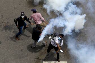 An anti-government protester throws back a gas canister during a protest demanding president and prime minister to step down near president's residence at Colombo, Sri Lanka. 9 July 2022 (Photo by Tharaka Basnayaka/NurPhoto via Getty Images)