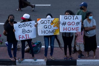 GALLE, SRI LANKA - JULY 09: Anti-government protesters hold placards during protests calling for the resignation of Sri Lanka's President Gotabaya Rajapaksa and Prime Minister Ranil Wickremesinghe on July 09, 2022 in Galle, Sri Lanka. Beleaguered Sri Lankan President Gotabaya Rajapaksa has said he would resign after he fled his official residence in Colombo following thousands of anti-government protesters storming the compound. (Photo by Buddhika Weerasinghe/Getty Images)