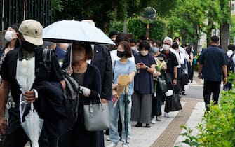 epa10066086 People make a long queue as they pay floral tribute to former Japanese Prime Minister Shinzo Abe at the ruling Liberal Democratic Party headquarters in Tokyo, Japan, 12 July 2022, as the funeral of Abe is held at Zojoji Temple. Abe was shot dead by Tetsuya Yamagami, a 41-year-old former member of the Japan Maritime Self-Defense Force, in Nara, western Japan, 08 July 2022 during an Upper House election campaign to support a candidate of his ruling party.  EPA/KIMIMASA MAYAMA