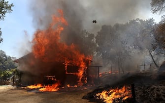 MARIPOSA, CALIFORNIA - JULY 23: A home burns as the Oak Fire moves through the area on July 23, 2022 near Mariposa, California. The fast moving Oak Fire burning outside of Yosemite National Park has forced evacuations, charred nearly 12,000 acres and has destroyed several homes since starting on Friday afternoon. The fire is zero percent contained. (Photo by Justin Sullivan/Getty Images)