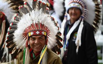 25 July 2022, Canada, Maskwacis: A Canadian native wearing a headdress smiles during Pope Francis' visit as part of his multi-day trip to Canada. Francis is visiting Canada to meet with the country's indigenous people, whose family members once suffered abuse, violence and humiliation in church-run boarding schools. Photo: Johannes Neudecker/dpa (Photo by Johannes Neudecker/picture alliance via Getty Images)