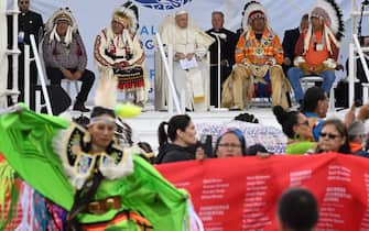 Members of the indigenous community (front) hold up the memorial banner, which was the first national, public record of the names of the children who did not return home from the residential schools across Canada, as Pope Francis meets with Indigenous leaders at Muskwa Park in Maskwacis, Alberta, Canada, on July 25, 2022. - Pope Francis will make a historic personal apology Monday to Indigenous survivors of child abuse committed over decades at Catholic-run institutions in Canada, at the start of a week-long visit he has described as a "penitential journey." (Photo by Patrick T. FALLON / AFP) (Photo by PATRICK T. FALLON/AFP via Getty Images)
