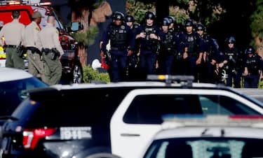 LOS ANGELES, CALIF. - JULY 24, 2022. LAPD officers and Sheriff's deputies stage at the entrance to Peck Park in San Pedro, where seven people were injured in a shooting on Sunday afternoon, July 24, 2022. (Luis Sinco / Los Angeles Times via Getty Images)