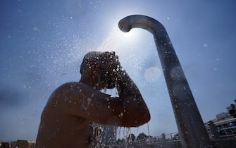 19 July 2022, Schleswig-Holstein, TravemÃ¼nde: A man cools off under a shower on the Baltic Sea beach in TravemÃ¼nde. Photo: Marcus Brandt/dpa (Photo by Marcus Brandt/picture alliance via Getty Images)