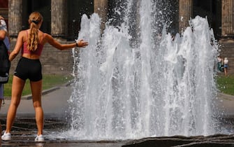 A girl cools off at a fountain in Berlins Mitte district on July 25, 2022 as temperatures were forecast to reach 36 degrees Celsius in the German capital. (Photo by David GANNON / AFP) (Photo by DAVID GANNON/AFP via Getty Images)