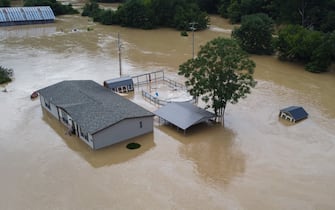 Homes submerged under flood waters from the North Fork of the Kentucky River are seen from a drone in Jackson, Kentucky, on July 28, 2022. - At least three people have died after torrential rains caused massive flooding in eastern Kentucky, leaving a number of people stranded on rooftops and in trees, the governor of the southeastern US state said Thursday. (Photo by LEANDRO LOZADA / AFP) (Photo by LEANDRO LOZADA/AFP via Getty Images)