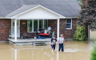 A couple abandons their home flooded by the waters of the North Fork of the Kentucky River in Jackson, Kentucky on July 28, 2022. - At least eight people have died after torrential rains caused massive flooding in eastern Kentucky, leaving a number of people stranded on rooftops and in trees, the governor of the southeastern US state said Thursday. (Photo by LEANDRO LOZADA / AFP) (Photo by LEANDRO LOZADA/AFP via Getty Images)