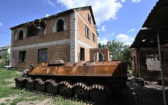 A destroyed Russian armored personnel carrier (APC) is seen in a yard of a heavily damaged house in the village of Mala Rogan, Kharkiv region on July 28, 2022, amid Russian invasion of Ukraine.  - Thousands of Ukrainians return to liberated but ruined homes in the country's east, AFP reports.  The Kharkiv region of 2.7 million that includes Mala Rogan saw 90 percent of housing destroyed in areas liberated from occupation, local media reported.  (Photo by Genya SAVILOV / AFP) (Photo by GENYA SAVILOV / AFP via Getty Images)