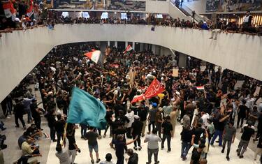epa10098624 Supporters of Iraqi Shiite cleric Muqtada al-Sadr, head of the Sadrist movement, gather inside the Iraqi parliament building after they stormed the 'Green Zone' in central Baghdad, Iraq, 30 July 2022. Thousands of supporters of the Shiite cleric Muqtada al-Sadr breached the heavily fortified Green Zone, home to government buildings and foreign embassies in Baghdad, for the second time in three days, protesting against a premiership candidate announced by the Shiite Coordination Framework earlier this week. Al-Sadr called on his supporters to sit in inside the Iraqi parliament building. EPA/AHMED JALIL