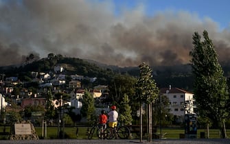 People watch the progression of a wildfire in Mafra on July 31, 2022. (Photo by PATRICIA DE MELO MOREIRA / AFP) (Photo by PATRICIA DE MELO MOREIRA/AFP via Getty Images)