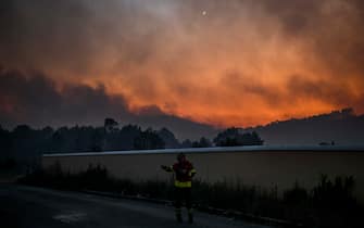 TOPSHOT - A firefighter watch the progression of a wildfire at the village of Asseiceira Pequena in Mafra on July 31, 2022. (Photo by PATRICIA DE MELO MOREIRA / AFP) (Photo by PATRICIA DE MELO MOREIRA/AFP via Getty Images)
