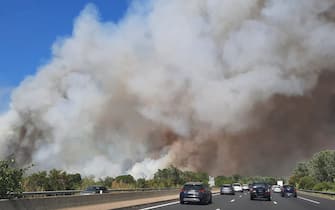 This image taken from a car window along a highway on July 31, 2022, shows thick white smoke from a fire near Aubais, southern France. - According to the French Interior Minister, the fire has taken out 200 hectares and injured four firefighters. (Photo by Benjamin GALY / AFP) (Photo by BENJAMIN GALY/AFP via Getty Images)