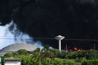 Black smoke from an oil tank on fire is seen in Matanzas, Cuba, on August 6, 2022. - The fire caused by lightning on Friday in a fuel depot in Matanzas, in western Cuba, spread to a second tank at dawn this Saturday and caused 49 injuries, official sources reported. (Photo by YAMIL LAGE / AFP) (Photo by YAMIL LAGE/AFP via Getty Images)