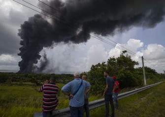 MATANZAS, CUBA - AUGUST 6: Flames and smoke rise from the Matanzas Supertanker Base, as firefighters and specialists work to quell the blaze which began during a thunderstorm the night before, in Matanzas, Cuba, Saturday, Aug. 6, 2022. (Photo by Yander Zamora/Anadolu Agency via Getty Images)