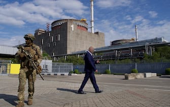 Pro-russian mayor of Energodar Andrey Shevtchik (C) walks past the Zaporizhzhia Nuclear Power Station in Energodar on May 1, 2022. - The Zaporizhzhia Nuclear Power Station in southeastern Ukraine is the largest nuclear power plant in Europe and among the 10 largest in the world.  *EDITOR'S NOTE: This picture was taken during a media trip organised by the Russian army.* (Photo by Andrey BORODULIN / AFP) (Photo by ANDREY BORODULIN/AFP via Getty Images)