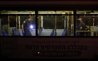 Israeli security inspect a bus after an attack outside Jerusalem's Old City, August 14, 2022. - Seven people were injured, two of them critically, after a shooting attack on a bus in Jerusalem's Old City, Israeli police and the national emergency medical services said early August 14, 2022. (Photo by AHMAD GHARABLI / AFP) (Photo by AHMAD GHARABLI/AFP via Getty Images)
