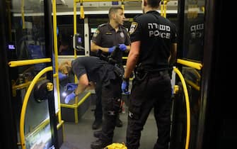 Israeli security inspect a bus after an attack outside Jerusalem's Old City, August 14, 2022. - Seven people were injured, two of them critically, after a shooting attack on a bus in Jerusalem's Old City, Israeli police and the national emergency medical services said early August 14, 2022. (Photo by AHMAD GHARABLI / AFP) (Photo by AHMAD GHARABLI / AFP via Getty Images)