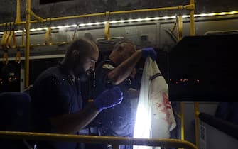Israeli security inspect a bus after an attack outside Jerusalem's Old City, August 14, 2022. - Seven people were injured, two of them critically, after a shooting attack on a bus in Jerusalem's Old City, Israeli police and the national emergency medical services said early August 14, 2022. (Photo by AHMAD GHARABLI / AFP) (Photo by AHMAD GHARABLI / AFP via Getty Images)