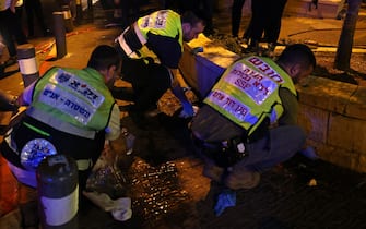 Zaka volunteers, an Ultra-Orthodox Jewish emergency response team, clean up blood stains after an attack outside Jerusalem's Old City, August 14, 2022. - Seven people were injured, two of them critically, after a shooting attack on a bus in Jerusalem's Old City, Israeli police and the national emergency medical services said early August 14, 2022. (Photo by AHMAD GHARABLI / AFP) (Photo by AHMAD GHARABLI/AFP via Getty Images)