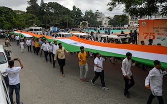 People take part in a procession carrying a giant Indian national flag on the occasion of 75th anniversary of Indias independence, in Bangalore on August 15, 2022. (Photo by Manjunath Kiran / AFP) (Photo by MANJUNATH KIRAN/AFP via Getty Images)