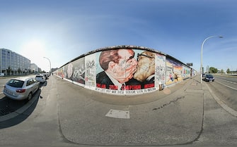 BERLIN, GERMANY - AUGUST 05: (EDITOR'S NOTE: Image was created as an Equirectangular Panorama. Import image into a panoramic player to create an interactive 360 degree view. Exclusive Content, outside of all subscription agreements - Premium Pricing applies) A mural by Russian painter Dmitri Vrubel depicts former Soviet leader Leonid Brezhnev kissing former East German communist leader Erich Honecker on the former Berlin Wall at the East Side Gallery on August 5, 2014 in Berlin, Germany. The East Side Gallery is a surviving portion of the Wall known for its murals and is one of the citys main tourist attractions. Germany will commemorate the 25th anniversary of the fall of the Berlin Wall, which was one of the many, sweeping events across central and eastern Europe as the Cold War came to an end, in November. The Berlin Wall, built by the communist authorities of the former East Germany, divided the city from 1961-1989. At least 138 people were killed while trying to flee from East Berlin into West Berlin. (Photo by Sean Gallup/360/Getty Images)