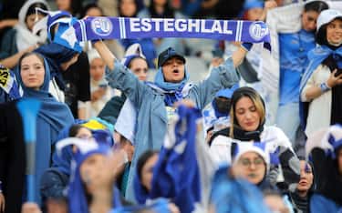 epa10138483 Iranian women soccer fans of Esteghlal-Tehran club cheer during the Iran Premier local soccer league match between Esteghlal and Mes-e Kerman at the Azadi stadium in Tehran, Iran, 25 August 2022.  Iranian authorities for the first time allowed around 500 women soccer fans to attend at Iran Premier league.  EPA/HOSSEIN ZOHREHVAND