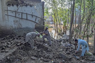 Residents remove debris of their houses damaged by flood waters following heavy monsoon rains in Charsadda district of Khyber Pakhtunkhwa on August 29, 2022. - The death toll from monsoon flooding in Pakistan since June has reached 1,061, according to figures released on August 29, 2022, by the country's National Disaster Management Authority. (Photo by Abdul MAJEED / AFP) (Photo by ABDUL MAJEED/AFP via Getty Images)