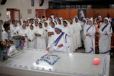 epa10160654 Sister M. Joseph M.C. (C), the new superior general of Missionaries Of Charity, lights a candle before a mass prayer at Mother House, near Mother's tomb on Mother Teresa's 25th death anniversary in Kolkata, India, 05 September 2022. Mother Teresa, who died on 05 September 1997, at the age of 87, was popularly known as the 'Saint of the Gutter' for her extraordinary love and dedication to poor, homeless and diseased people. She won the Nobel Peace Prize in 1979. Mother Teresa was canonized as a saint by Pope Francis in 2016.  EPA/PIYAL ADHIKARY
