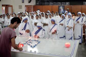 epa10160660 Nuns light the candles during a mass prayer near Mother's tomb at Mother House on Mother Teresa's 25th death anniversary in Kolkata, India, 05 September 2022. Mother Teresa who died on 05 September 1997, at the age of 87, was popularly known as the 'Saint of the Gutter' for her extraordinary love and dedication to poor, homeless and diseased people. She won the Nobel Peace Prize in 1979. Mother Teresa was canonized as a saint by Pope Francis in 2016.  EPA/PIYAL ADHIKARY