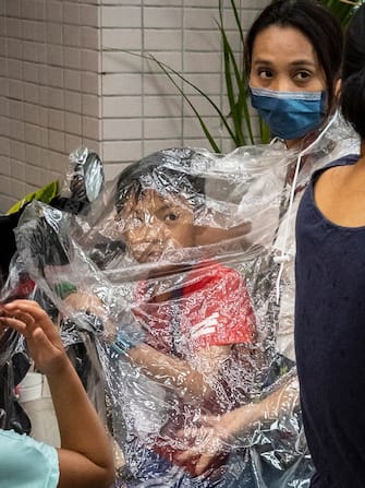 September 1, 2022, Taipei, Taiwan, China, Republic of China: A woman covers her baby with plastic sheeting to protect it from the rain in downtown Taipei, Taiwan.  Meteorologists on Thursday warned of coastal swells and rain across Taiwan over the weekend after Super Typhoon Hinnamnor merged with a tropical depression.  (Credit Image: © Wiktor Dabkowski / ZUMA Press Wire)
