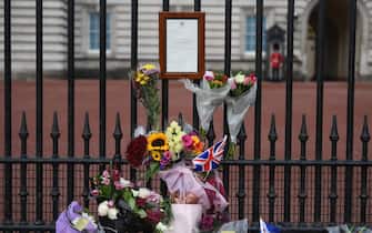 epa10172679 Flowers hang next to the Buckingham Palace statement announcing the death of Queen Elizabeth II, in London, Britain, 09 September 2022. Britain's Queen Elizabeth II died at her Scottish estate on 08 September 2022. The 96-year-old queen was the longest-reigning monarch in British history.  EPA/NEIL HALL