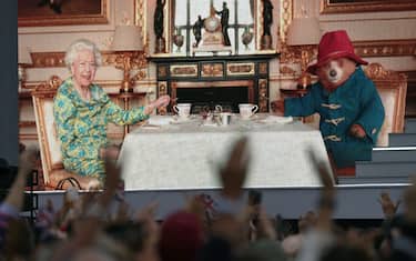 The crowd watching a film of Queen Elizabeth II having tea with Paddington Bear on a big screen during the Platinum Party at the Palace staged in front of Buckingham Palace, London on day three of the Platinum Jubilee celebrations for Queen Elizabeth II. Picture date: Saturday June 4, 2022. (Photo by Victoria Jones/PA Images via Getty Images)