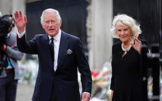 epaselect epa10173573 Britain's King Charles III (L) and Camilla, the Queen Consort, look at the floral tributes left outside Buckingham Palace in London, Britain, 09 September 2022. Britain's Queen Elizabeth II died at her Scottish estate, Balmoral Castle, on 08 September 2022. The Prince of Wales became King after the death of his mother and will be known as King Charles III.  EPA / OLIVIER HOSLET